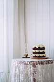 Chocolate sponge cake with white icing on a table