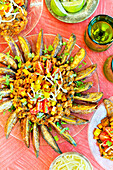 Vegetarian three-bean chilli fries on a pink background