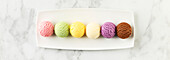Set of various ice-cream scoops on a white marble background. Strawberry, pistachio, mango, vanilla, blueberry and chocolate ice cream. Top view, laid flat
