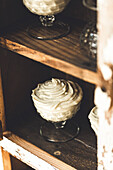 Vanille-Mousse-Dessert in einem Glas auf einem rustikalen Holzbrett serviert