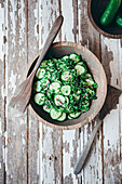 A fresh cucumber salad on a wooden background