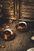 Fresh black coffee served in a copper cup and saucer