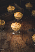 Puddingtassen mit Orangenmousse auf einem Holzuntergrund
