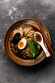 Ramen, Asian noodles in broth with beef tongue, mushrooms and eggs in a bowl