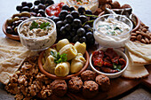Mediterranean diet charcuterie board grazing platter on dark slate background closeup.