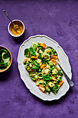 Green Peas Cucumber Potato and Tomato Salad on Purple Background with dressing