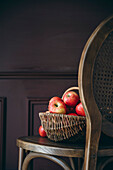 Äpfel in einem Korb vor dunklem Hintergrund