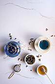 Blue butterfly pea flower tea on white marble background top view flatlay, with negative copy space.