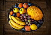 Various ripe fruits in a basket. Top view.