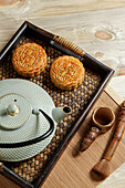 Mooncake for Mid-Autumn Festival, concept of traditional festive chinese food on an Asian wooden tray with teapot