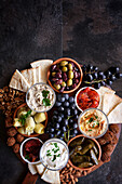 Mediterranean diet charcuterie board grazing platter on dark slate background, with negative copy space.