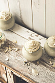 Vanilla mousse dessert served in a glass on a rustic wooden board