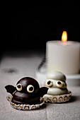Ghost and bat sweets over table for Halloween; made with cookie base, dulce de leche fill and chocolate coating