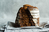 Front view of stack of rye bread slices on grey cloth napkin against blurred light background