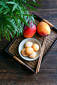 Japanische Mango-Mochi-Törtchen mit Eiscreme auf einem klassischen asiatischen Holztablett