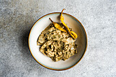 Plate of Georgian green beans with walnut sauce from above against a light background