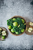A selection of healthy green foods, including apples and kale