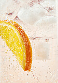 Lemonade in a glass with fizzy bubbles and a slice of orange
