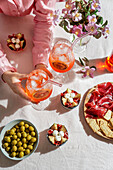 aperol spritz cocktail, on a pale pink linen tablecloth, shadows, sunlight, summer drink in glass