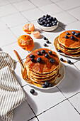 Pancake stack on a white tiled background with hard light