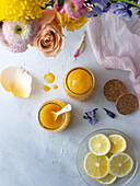 Zitronenquark in Gläsern, dekoriert mit Frühlingsblumen und Pastellfarben
