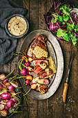 Steak au poivre sliced with Cream Sauce and Roasted Radishes on Metal Plate
