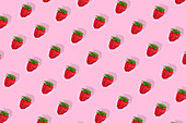 Modern retro color theme pattern of red strawberries against a pink background.