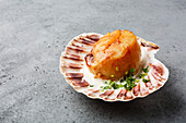 Fried Scallop with butter creamy sauce served in cockleshell on concrete background copy space