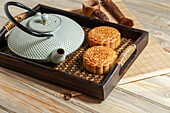 Mooncake for Mid-Autumn Festival, concept of traditional festive chinese food on an Asian wooden tray with teapot