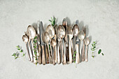 Rustic vintage cutlery on grey stone background flat lay from above