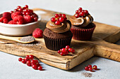 Schokoladen-Cupcake mit Zuckerguss und roten Früchten