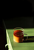 Kaffee im Glasbecher auf grünem Tisch