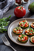 Baked zucchini with tomatoes and cheese on a plate.