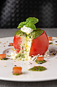 Sliced raw tomato with ricotta and basil pesto