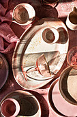 Ein Margarita-Glas auf rosa Hintergrund mit Geschirr