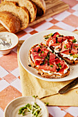 Ricotta and Parma ham toast with balsamic drizzle and cress on a tiled background