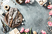 Ostertisch mit Frühlingsblumen und Besteck auf dunkelblauem Hintergrund, Draufsicht, flach gelegt. Fröhliche Ostern Konzept für Cafés und Restaurants. Raum kopieren
