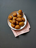 Sliced roast potatoes, top view on grey background