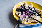 Tasty traditional Ukrainian dumplings with blueberry and sour cream