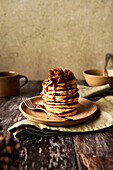 Apple Cinnamon Pancake Stack on Wooden Surface and Sage Green Background