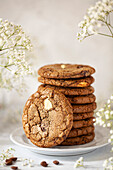 A stack of chocolate chip and coffee flavoured biscuits, with one leaning against the side of the stack. of coffee biscuits with