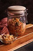 Healthy probiotic Korean style Kimchi in glass jar close up against a dark background.
