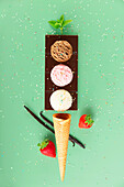 Chocolate, vanilla, strawberry scoops, waffle cone and ingredients on green background with colorful sprinkles, levitating concept. Spring or summer mood