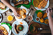 Top view of an unrecognisable female person eating various delicious Latin American dishes while having lunch in a restaurant in daylight