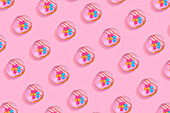 Modern retro colour theme pattern with pink donuts against a pink background