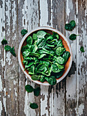Spinach in a bowl on a wooden table