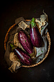 Three aubergines in a basket