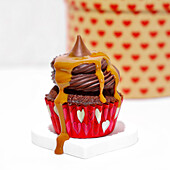 Chocolate cupcake with toffee sauce on white background