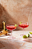 A Cosmopolitan cocktail in a traditional glass on a pink bar