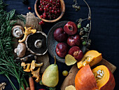 Ingredients for autumn dishes on a dark blue background. Flat-lay of autumn vegetables, berries and mushrooms from the local market. Vegan ingredients